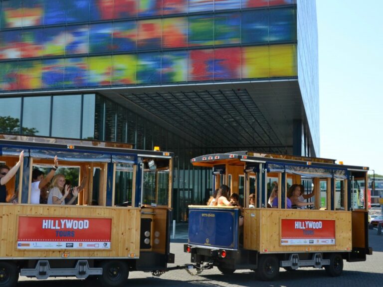De tram van Hillywood Tours met bezoekers voor het gebouw van Beeld & Geluid op het Media Park